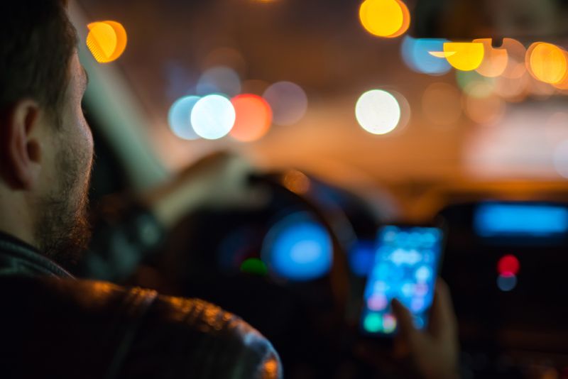 man texting while driving at night time