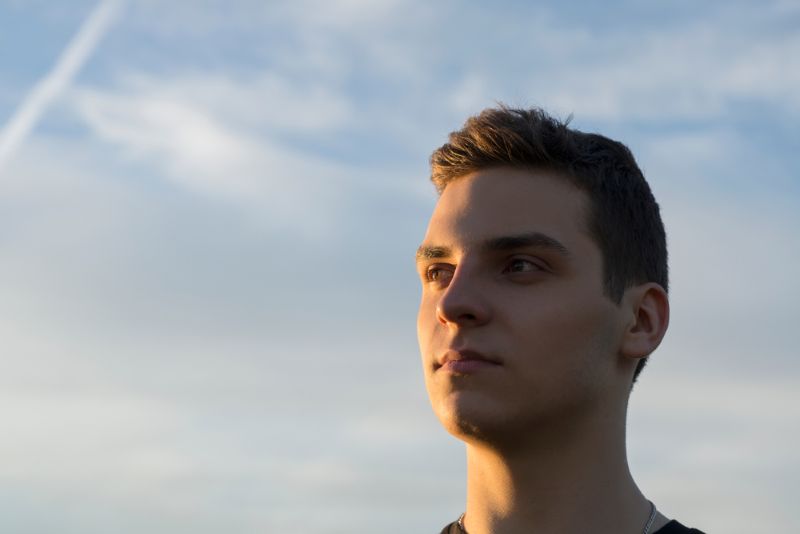Young man outside staring into the distance